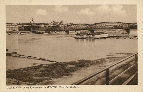 Fotografia czarno-biała. Warszawa, widok na Wisłę, a w tle most Kierbedzia. 